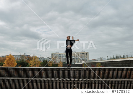 A woman warms up before sports classes A woman warms up before sports classes 97170552