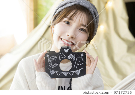 一位年輕女子坐在吊床上展示字母 97172736