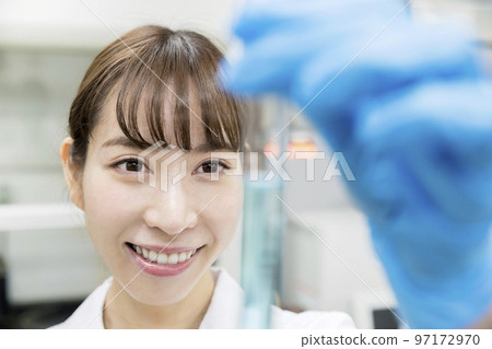 Research, development, experiment image, young female researcher looking at test tube 97172970