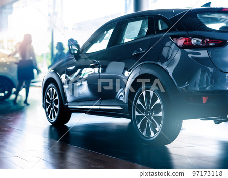 New SUV car in modern luxury showroom on blur saleswoman and customer. Car dealership office concept. Dealer agent business. Automobile leasing service. Dealer company. New car purchase. Auto sale. 97173118