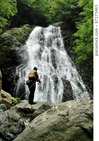 Male angler lure fishing at Kaminari Falls of Hayato River 97173465