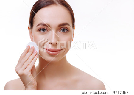 Beautiful brunette removes makeup from her face. Beautiful brunette removes makeup from her face. 97173683