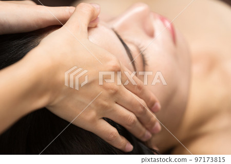 A woman is receiving a head massage. 97173815