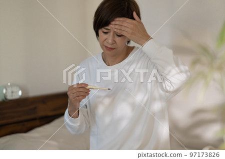 A woman measuring fever, cold, headache, body temperature 97173826