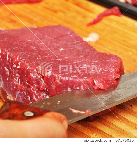 Clean very fresh red raw cow meat and a sharp knife 97176830