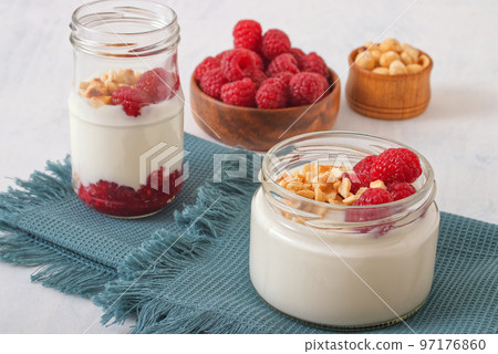 Healthy nutrition food, plain Greek yogurt, fresh raspberries and crushed hazelnuts on white background. Healthy nutrition food, plain Greek yogurt, fresh raspberries and crushed hazelnuts on white background. 97176860