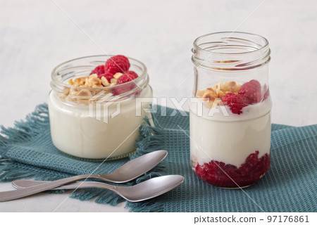 Healthy nutrition food, plain Greek yogurt, fresh raspberries and crushed hazelnuts on white background. Healthy nutrition food, plain Greek yogurt, fresh raspberries and crushed hazelnuts on white background. 97176861