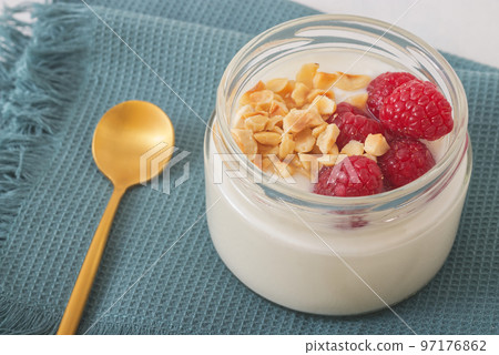 Healthy nutrition food, plain Greek yogurt, fresh raspberries and crushed hazelnuts on white background. Healthy nutrition food, plain Greek yogurt, fresh raspberries and crushed hazelnuts on white background. 97176862