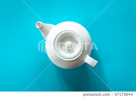 White teapot with tea on a blue background, flat lay. White teapot with tea on a blue background, flat lay. 97178644
