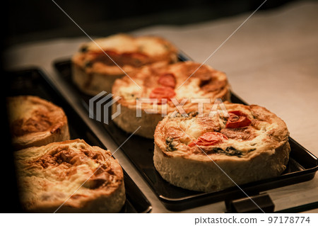 Small puff pies with vegetables and meat, quiches in a cafe window. Small puff pies with vegetables and meat, quiches in a cafe window. 97178774