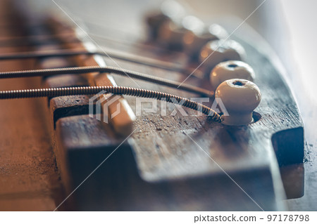 Acoustic guitar bridge and strings close up. 97178798