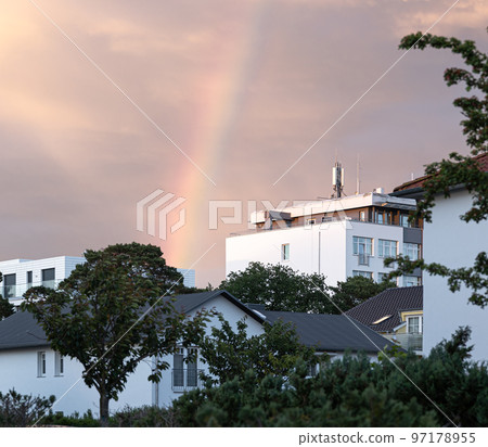 Rainbow in the sky in a residential area among houses. 97178955