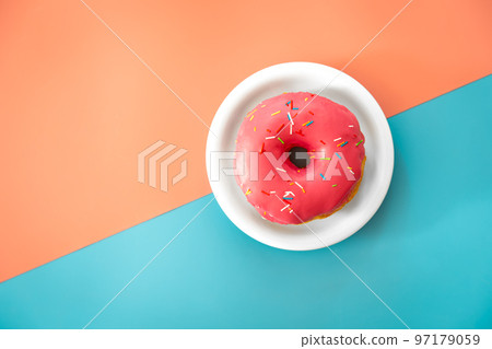 Donut in pink icing on a colored background, flat lay. Donut in pink icing on a colored background, flat lay. 97179059