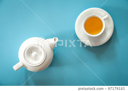 Cup of tea and teapot on a blue background, flat lay. 97179181