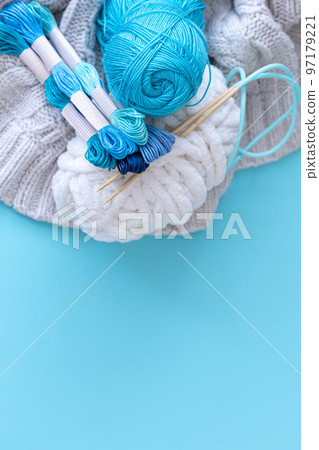 Threads of different colors on a blue background. 97179221