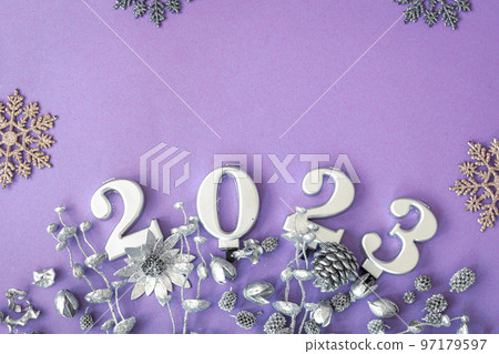Lilac Christmas background with numbers 2023 and decor details, flat lay. 97179597