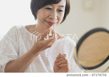 Middle Japanese woman doing makeup 97179738