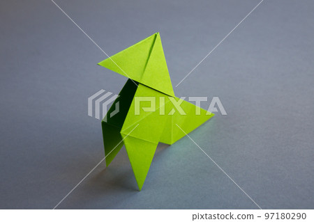 Green paper hen origami isolated on a grey background Green paper hen origami isolated on a grey background 97180290