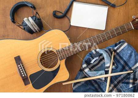 Music background with guitar, headphones and notepad, top view. 97180862