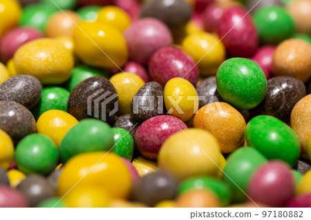 Peanuts covered with multicolored glaze, close up. 97180882