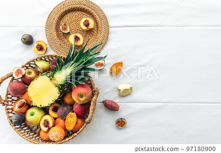 Pineapple and other exotic fruits in a basket on a white background, top view. Pineapple and other exotic fruits in a basket on a white background, top view. 97180900