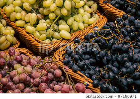 Baskets with different types of grapes on a supermarket showcase. Baskets with different types of grapes on a supermarket showcase. 97180971