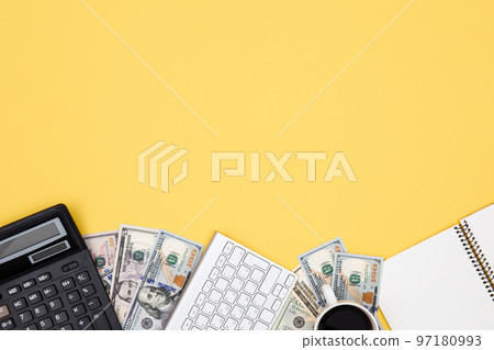 Calculator, money, notepad and keyboard on yellow background, flat lay. 97180993