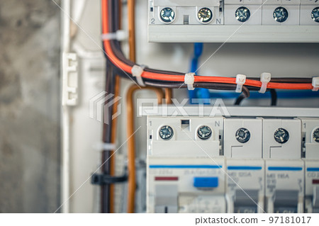 Close up circuit breakers and wire in control panel. 97181017