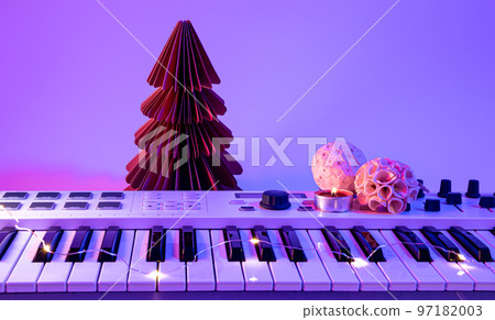 Christmas background with midi keyboard and holiday decor with neon lights. 97182003