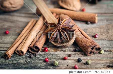 Composition with star anise and cinnamon sticks on a wooden background. 97182054