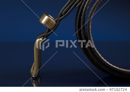 Black leather belt on a dark blue background. Black leather belt on a dark blue background. 97182724