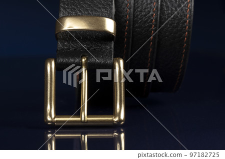 Black leather belt on a dark blue background. Black leather belt on a dark blue background. 97182725