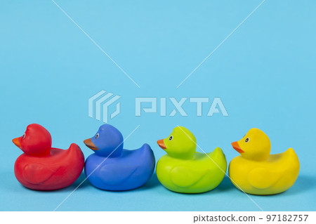 Multi-colored rubber ducks on a blue background. Multi-colored rubber ducks on a blue background. 97182757