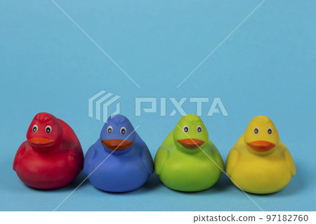 Multi-colored rubber ducks on a blue background. Multi-colored rubber ducks on a blue background. 97182760