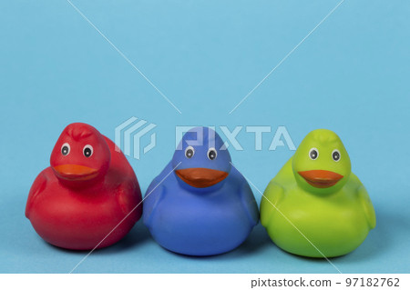 Multi-colored rubber ducks on a blue background. Multi-colored rubber ducks on a blue background. 97182762