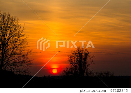 The bright red sun sets over the horizon The bright red sun sets over the horizon 97182845