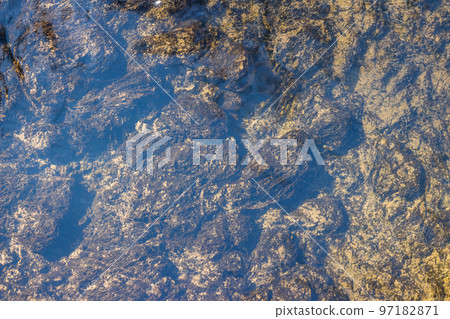 Bluish sheen of clear water and seaweed at the bottom of the creek Bluish sheen of clear water and seaweed at the bottom of the creek 97182871