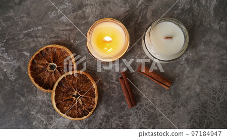 Handmade candle with wooden wick in glass jar with cinnamon and dry oranges Handmade candle with wooden wick in glass jar with cinnamon and dry oranges 97184947