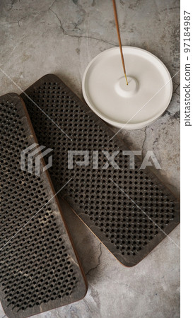 Incense on a white ceramic stand and boards with nails for yoga classes. Incense on a white ceramic stand and boards with nails for yoga classes. 97184987