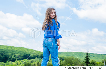 Hip and stylish. hipster kid. happy childrens day. happy childhood. smiling child with curly hairstyle. hair beauty and care. kid fashion style. teenage girl on sky background outdoor 97185326