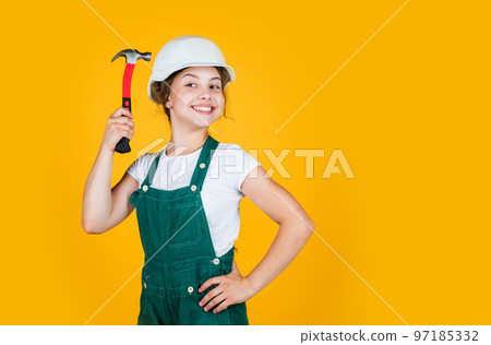 teen girl builder in protective helmet use hammer, protection, copy space teen girl builder in protective helmet use hammer, protection, copy space 97185332