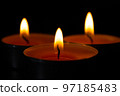 Composition of three candles on dark luxury night background. Black table, side view. Candles Burning at Night. Orange taper burning in focus, foreground. illustration design. 97185483