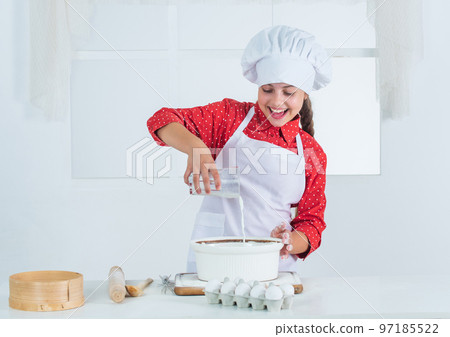 looking good. teen girl preparing dough. making cake by recipe. time to eat. happy child cooking in kitchen. bake cookies in kitchen. professional and skilled baker. kid in chef uniform and hat 97185522