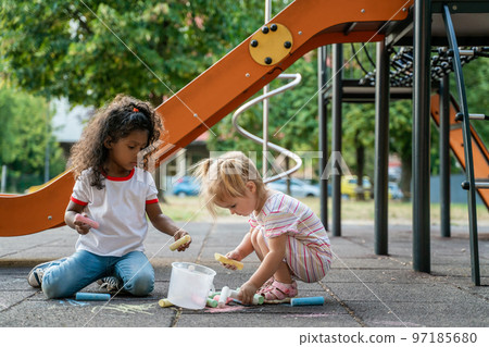 Two little girls playing togather on the playground Two little girls playing togather on the playground 97185680