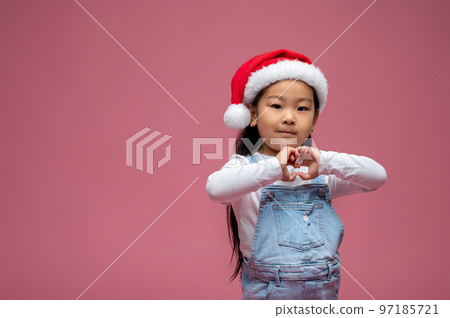 Cute little girl in santa hat looking happy and sweet 97185721