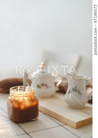 Homemade salted caramel sauce in jar on rustic wooden table. 97186573