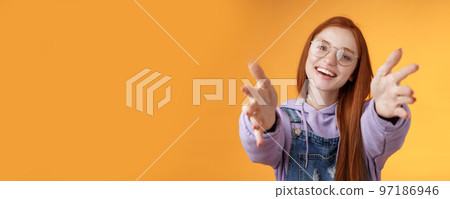 Come here let hold. Attractive silly friendly happy smiling redhead woman stretch arms camera grab product wanna tight friendship hugs grinning embracing cuddling besties, orange background 97186946
