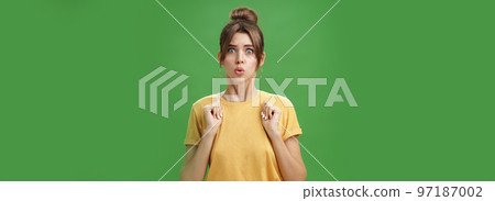 Studio shot of silly insecure and timid young wife feeling troubled and concerned, pressing hands to body folding lips and frowning looking scared and nervous facing troublesome situation, worry Studio shot of silly insecure and timid young wife feeling troubled and concerned, pressing hands to body folding lips and frowning looking scared and nervous facing troublesome situation, worry 97187002
