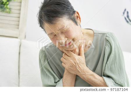 An elderly woman whose throat is clogged at home An elderly woman whose throat is clogged at home 97187104