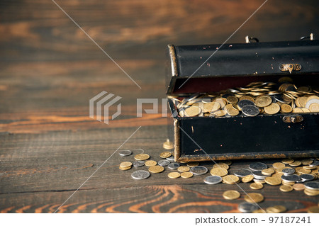Chest full of coin on wooden background with copy space for your text 97187241